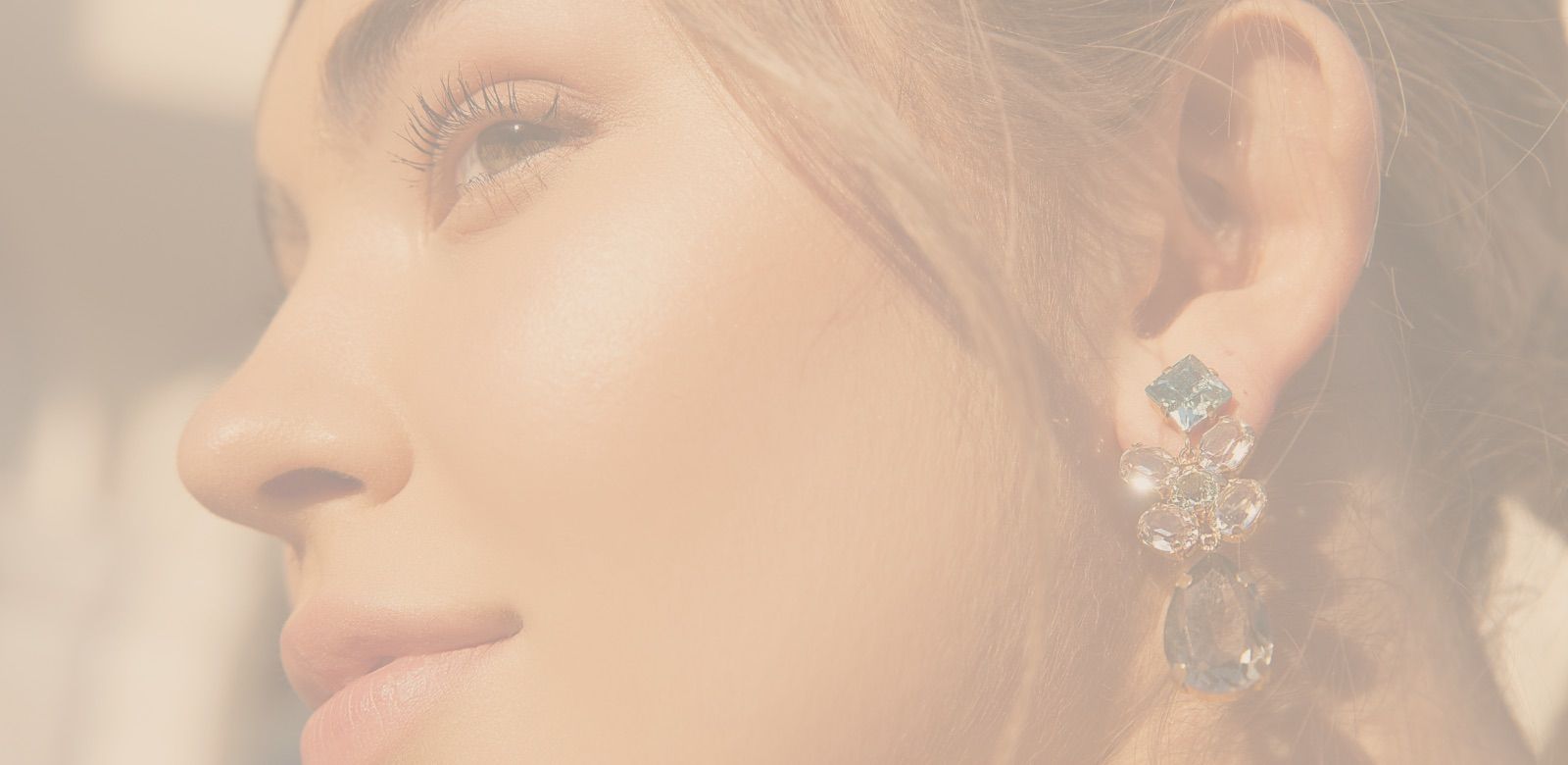 Close-up of a woman's face with earrings.
