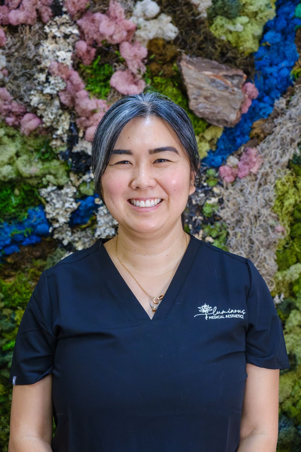 Smiling healthcare professional in medical attire.