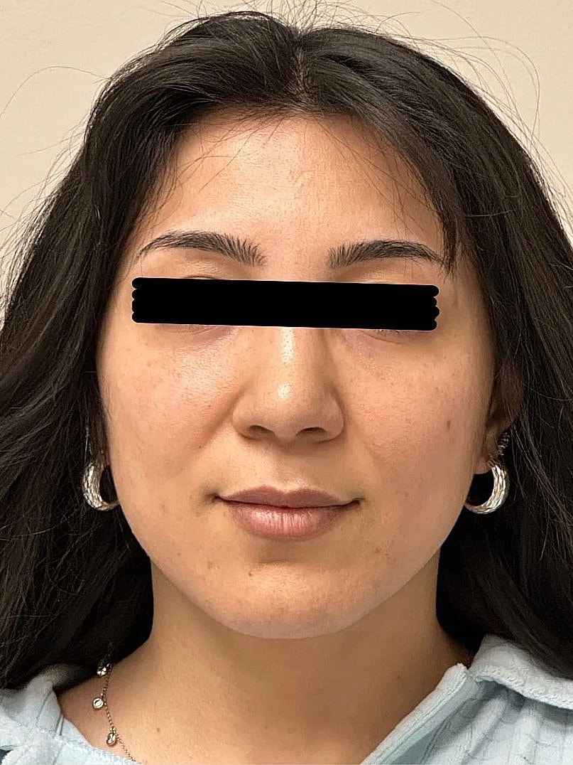 Young woman with long hair and earrings.